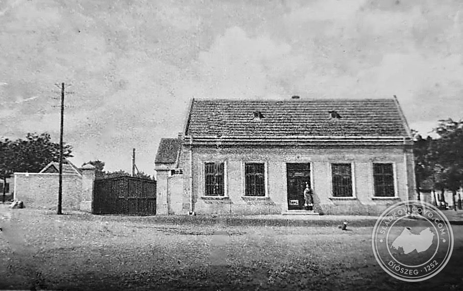 Budova predajne Potravného družstva "Szövetkezet" na námestí okolo roku 1915. Tento obchod bol predchodcom samoobsluhy "Jednota", ktorá bola postavená na mieste tejto budovy.