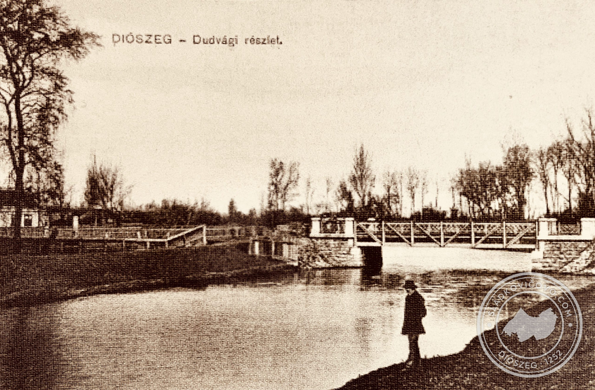 A 20. század első évtizedéből származó képeslapon a Dudvág látható a közúti híddal, egészen balra pedig a jegyzőség épülete. A mai városi hivatal épülete még nem áll.